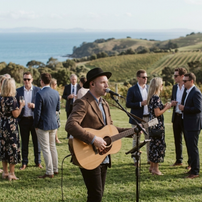 Acoustic wedding musician performing with vineyard and sea views