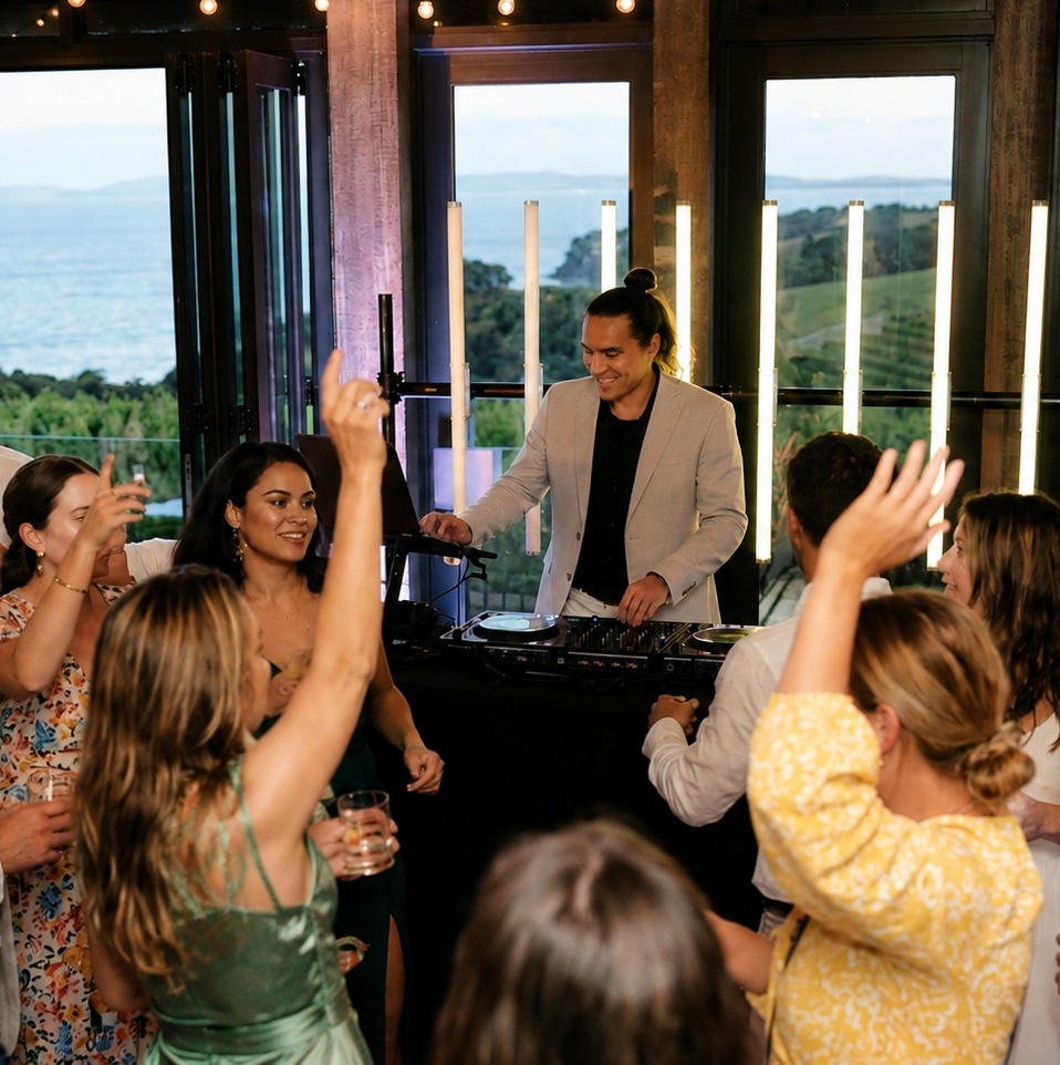 DJ performing for dancing wedding guests at a Waiheke Island venue with sea views