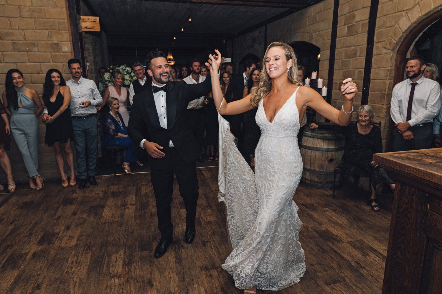 Newlyweds sharing their first dance surrounded by wedding guests